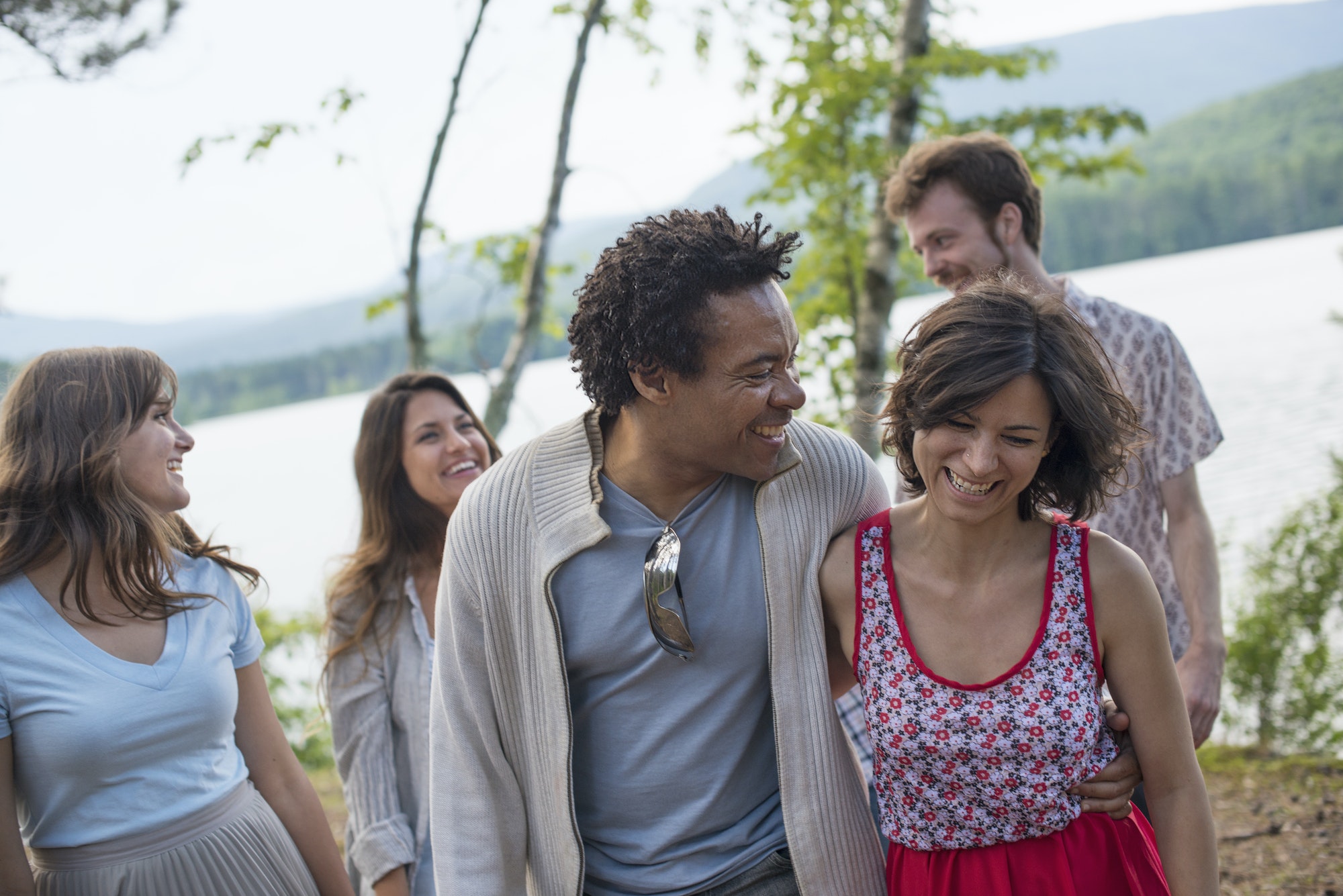 A group of people enjoying a leisurely walk by a lake.