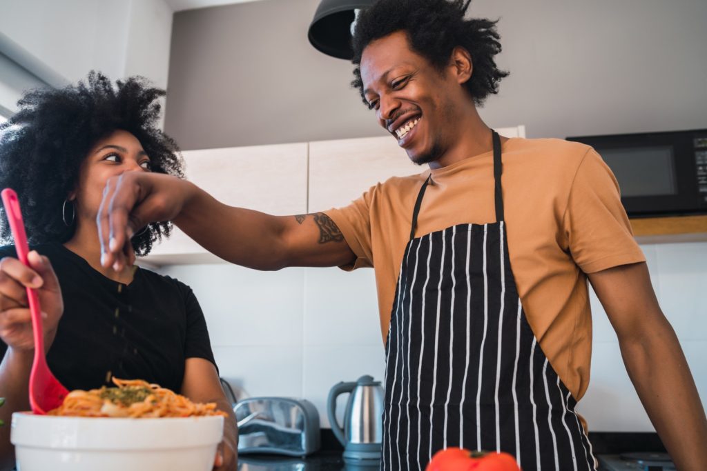 Afro couple cooking together in the kitchen.