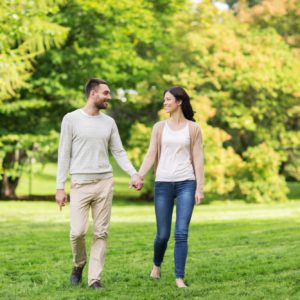 happy couple walking in summer park